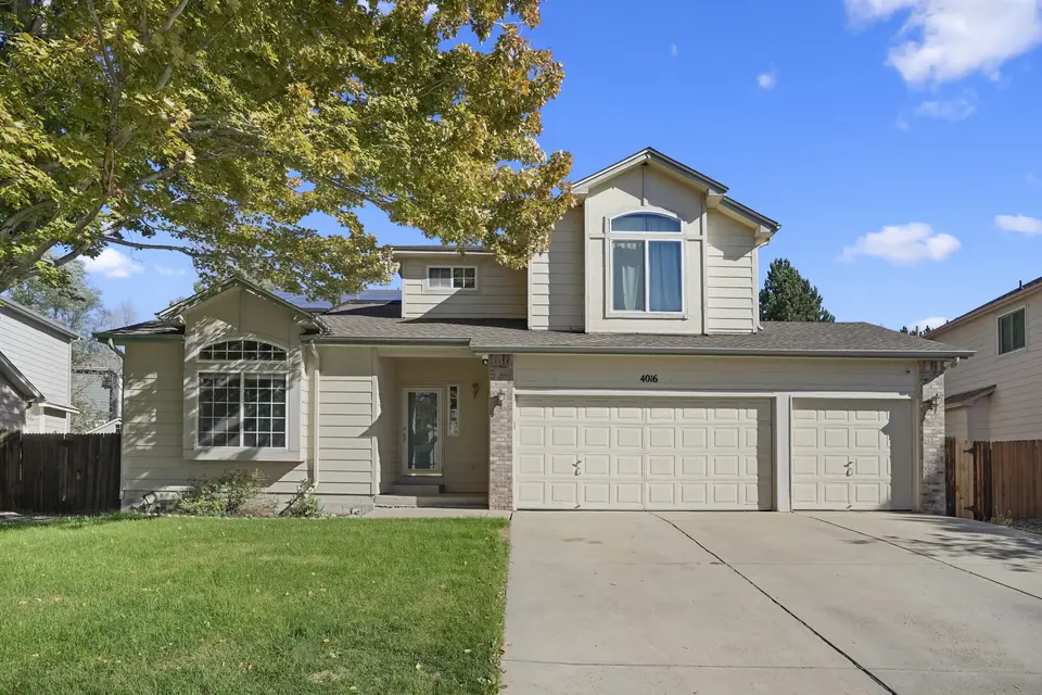 Front of 4016 S Kirk Ct: two-story tan house with a three-car garage and a mature shade tree